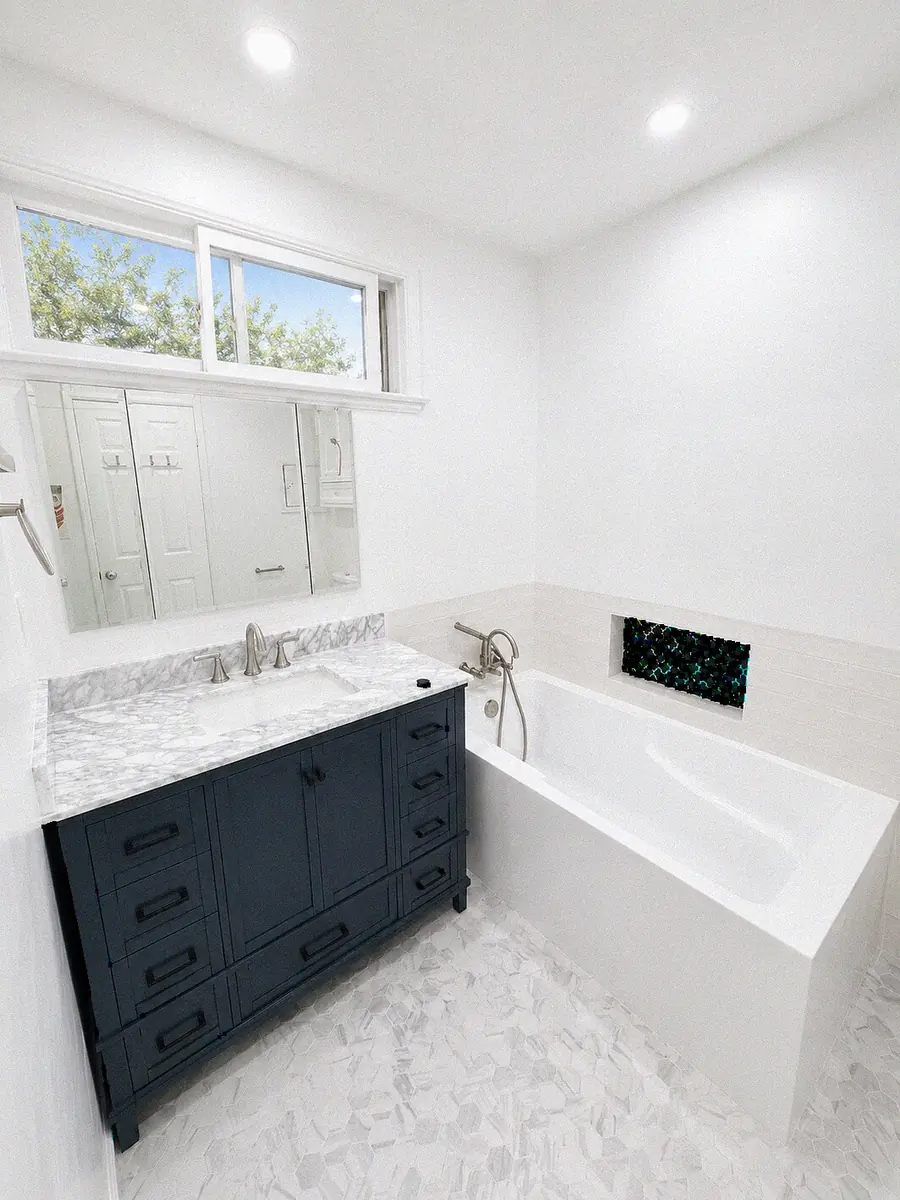 Navy vanity, soaking tub and tiled accent niche — YKCA Bay Area remodel
