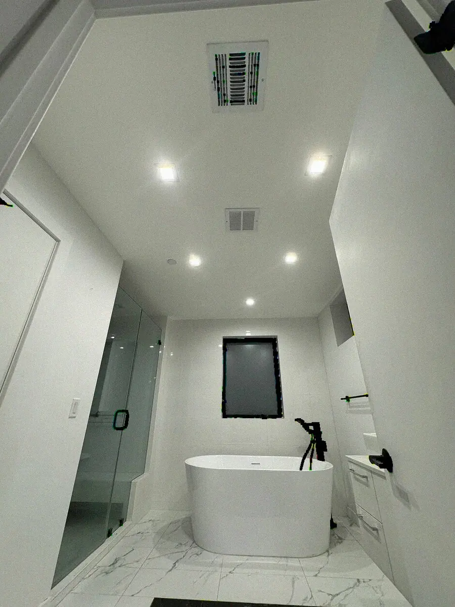 Bay Area bathroom remodel by YKCA — freestanding tub, black marble-look porcelain and a double vanity